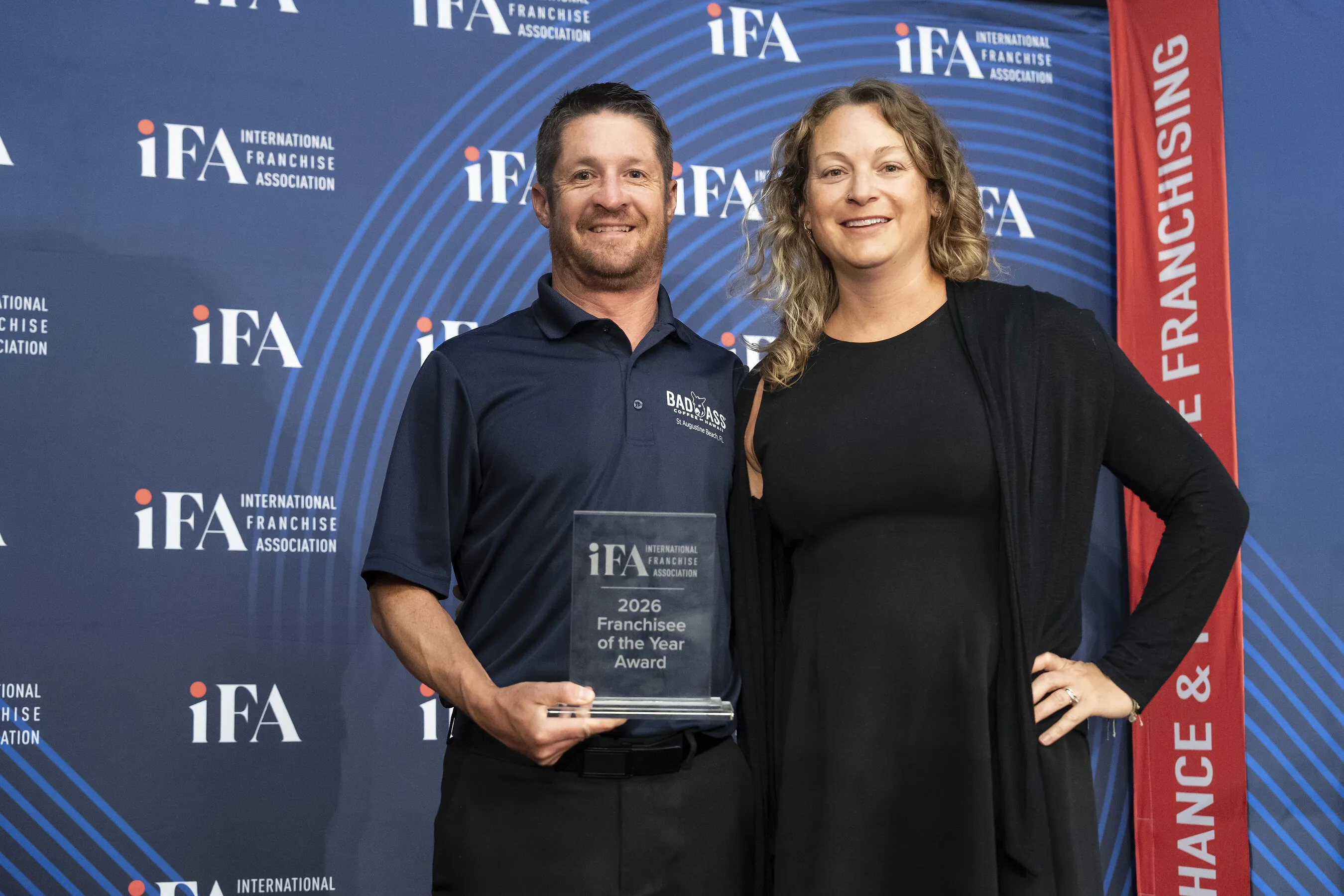 Allen Stanczak holds a 2026 Franchisee of the Year award beside Christy Stanczak at an IFA event.