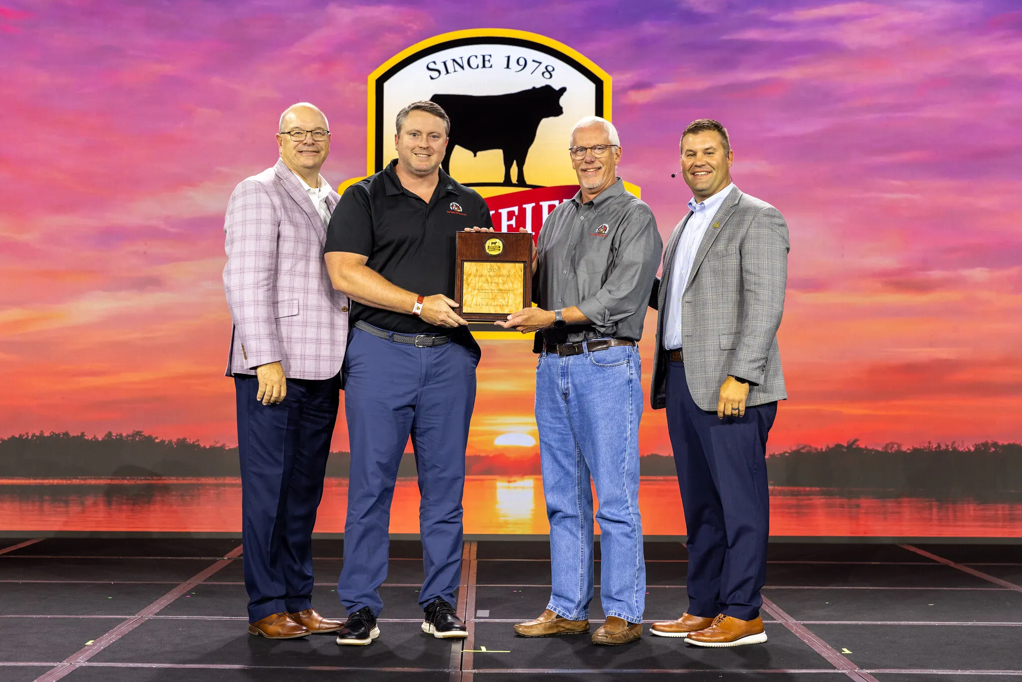 Four people present a Rising Star Award in front of the New York Butcher Shoppe logo.