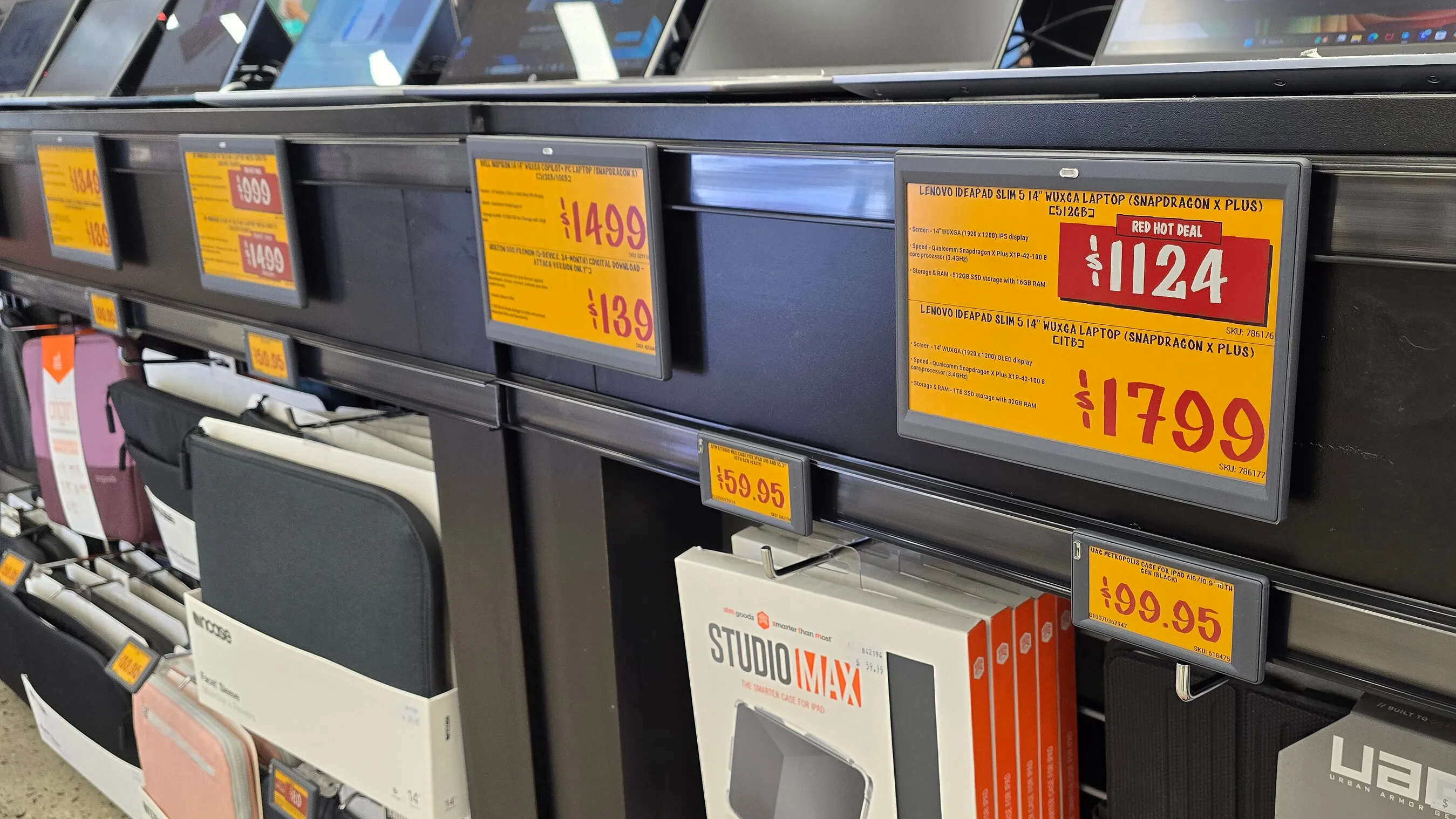 Laptop accessories displayed beneath electronic price labels in a JB Hi-Fi store.